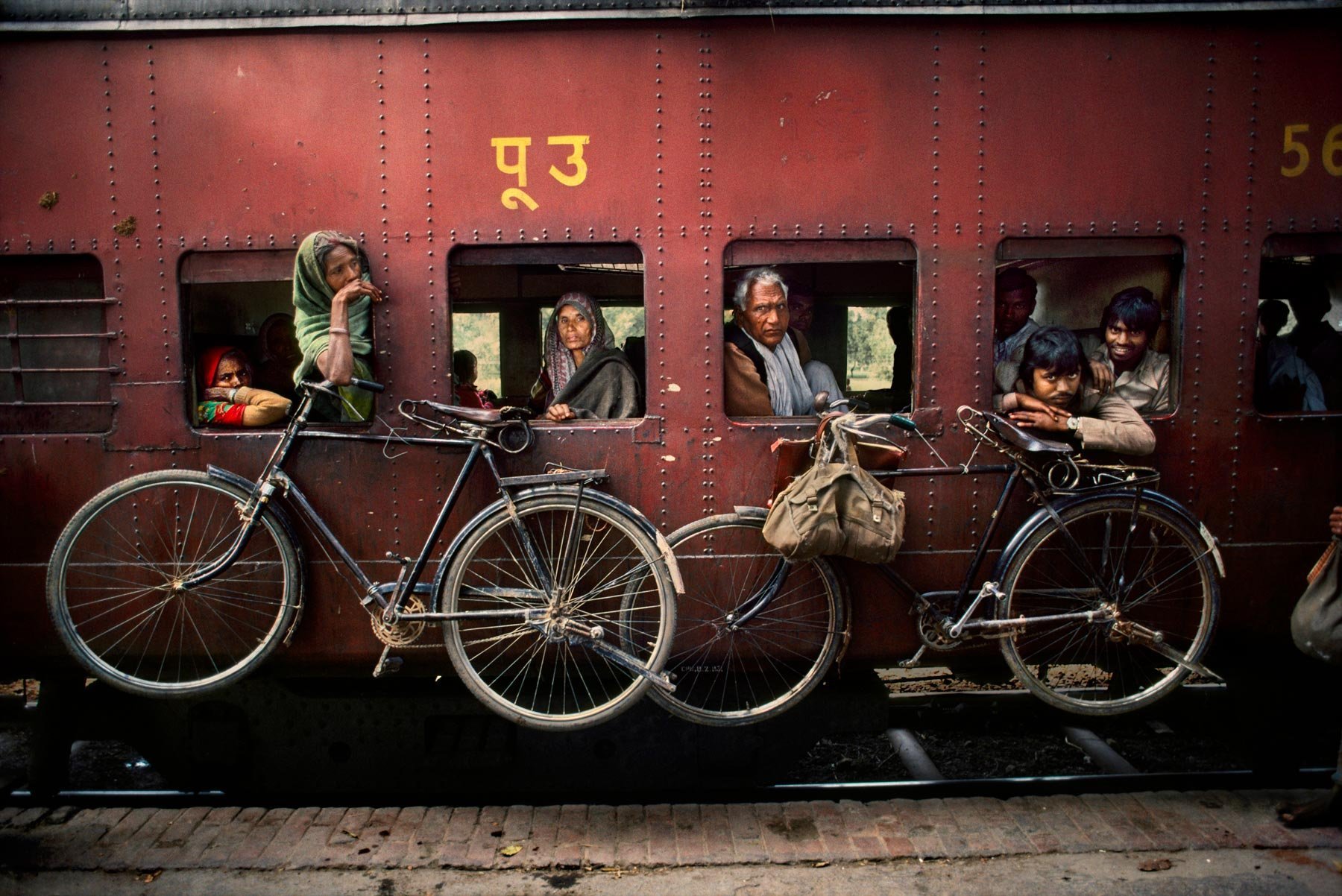 Bicycles hanging from the side of a train